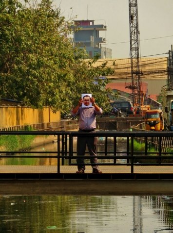 A passer-by holding a photo of Yi Soksan in a sewage canal in Ph