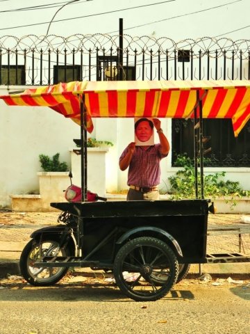 A man holding a photo of Ny Sokha in a street of Phnom Penh