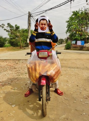A bread seller holding a photo of Yi Soksan