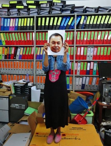 A office worker holding a photo of Yi Soksan