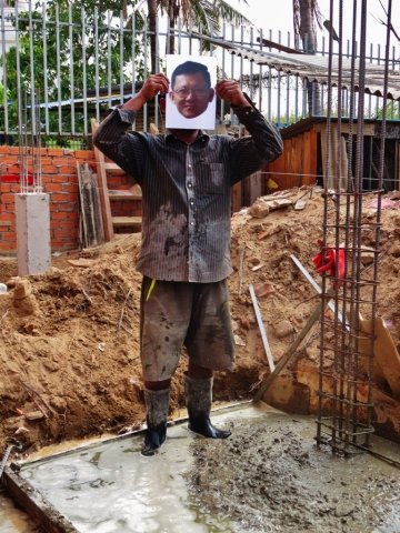 A construction worker holding a photo of Ny Chakrya